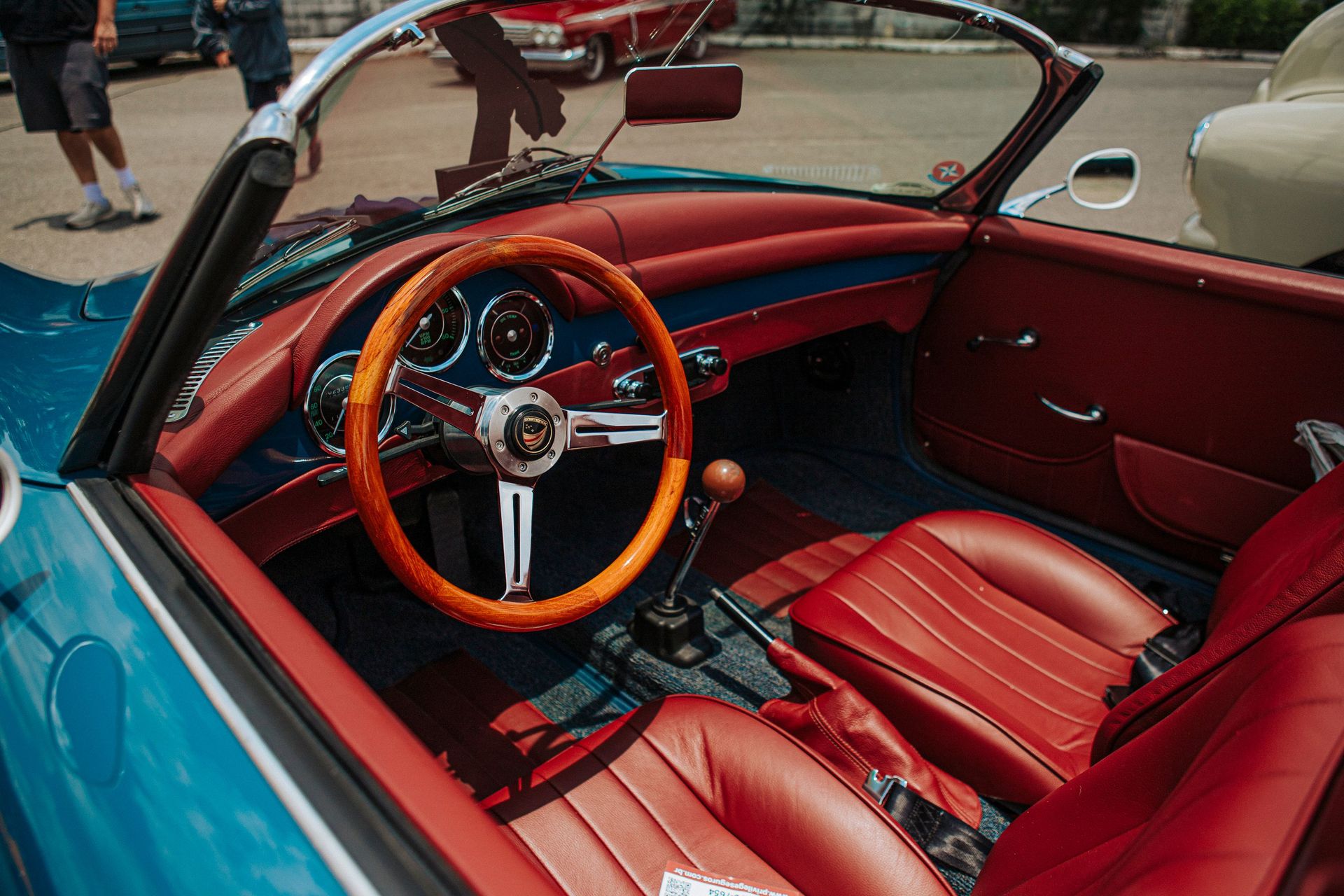 Luxurious classic convertible interior with vibrant red leather and wood accents, perfect for vintage car enthusiasts.